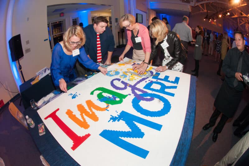 Attendees at Meadowbrook's campaign launch assemble a LEGO model of the campaign logo.